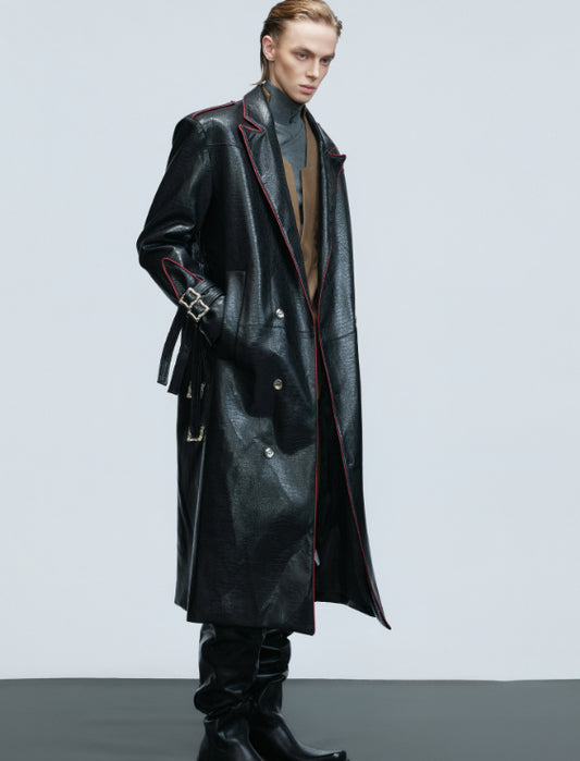 Manteau long à larges épaules, ceinture métallique et fourrure.