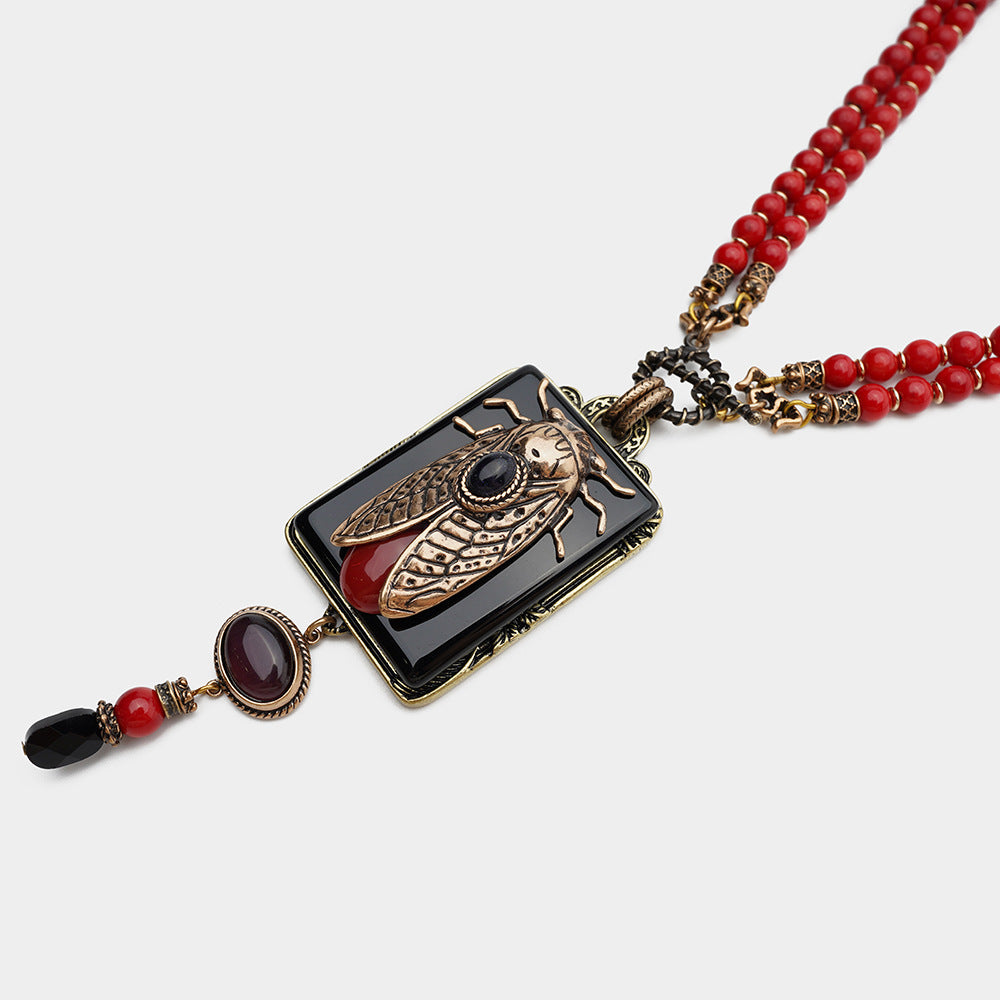 Collier en perles de bambou de la mer Rouge avec chaîne en agate naturelle et cigale dorée