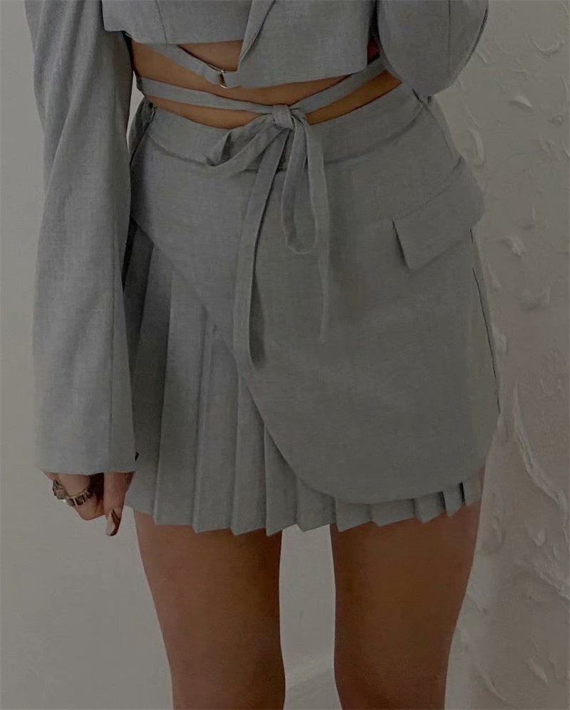 Tenue rétro streetwear : veste courte, gilet, jupe plissée taille haute.