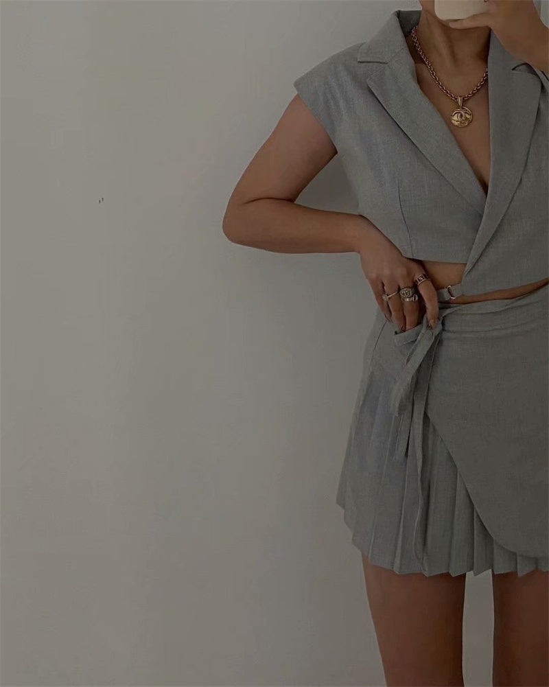 Tenue rétro streetwear : veste courte, gilet, jupe plissée taille haute.