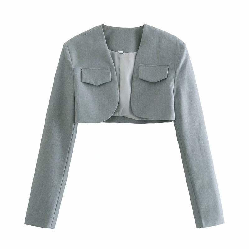 Tenue rétro streetwear : veste courte, gilet, jupe plissée taille haute.