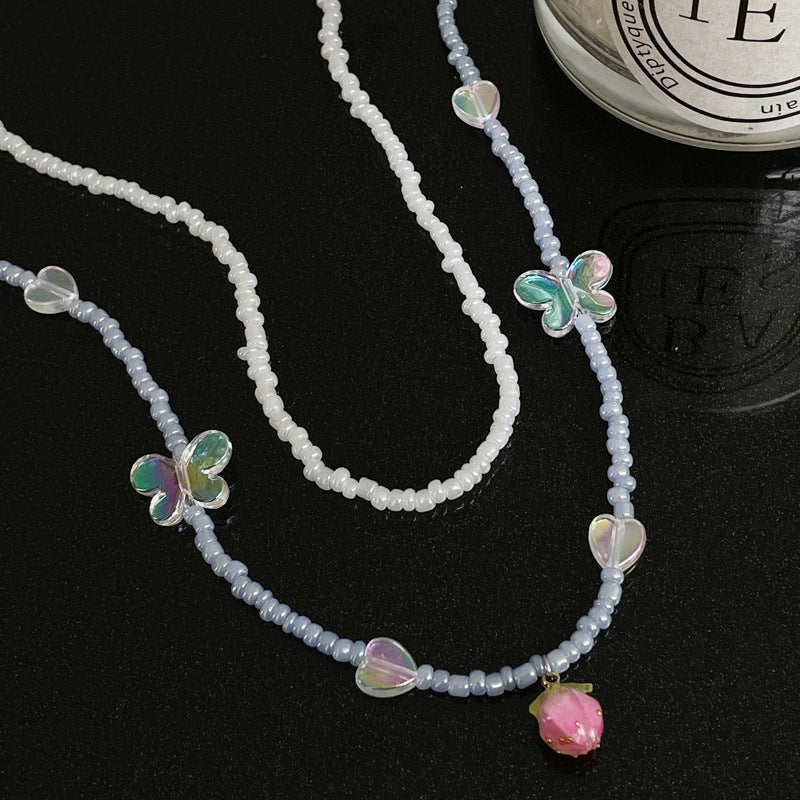 Collier double rang de perles et fleurs pour femme, un bijou raffiné et léger, empreint de luxe.